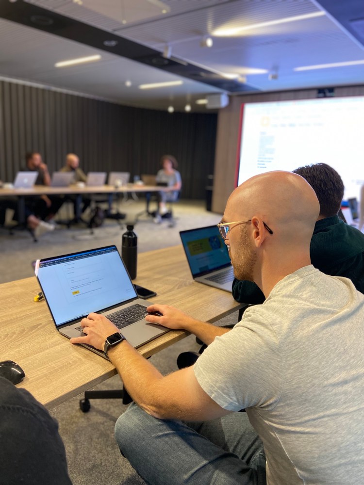 Focus on a person with his laptop open, tabbing, attending the training.