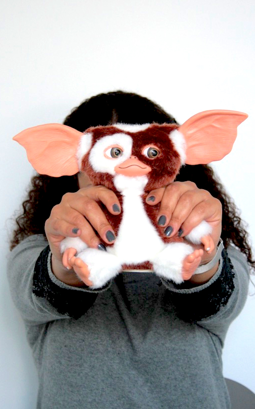 Nadia holding a Gremlin doll in front of her face.