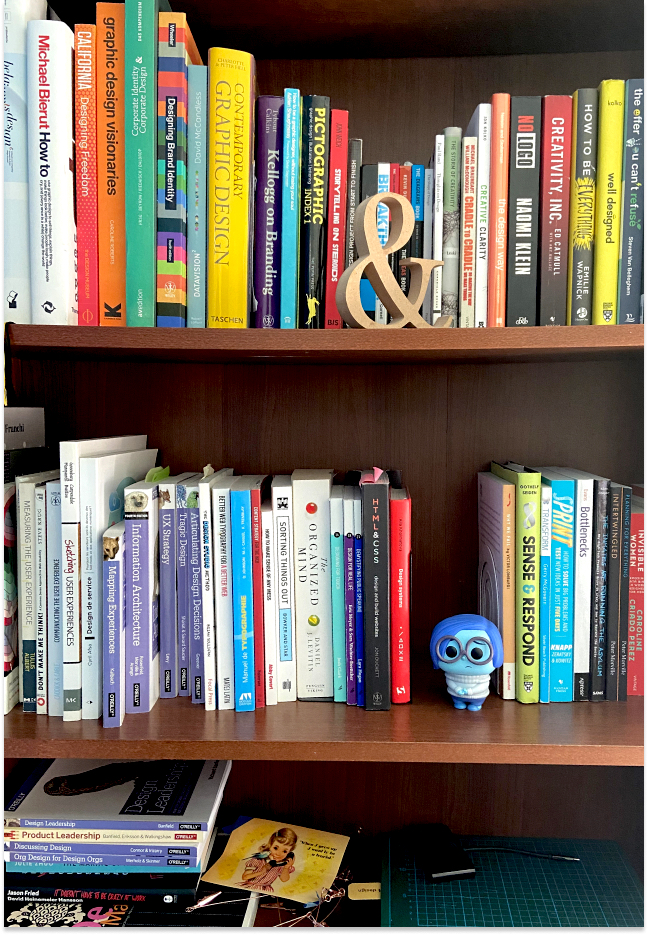 Shelf with 3 rows of books about Design.