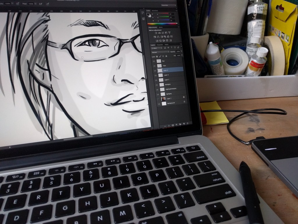 Computer screen displaying digital portrait sketch. Next to Wacom pen and art supplies.